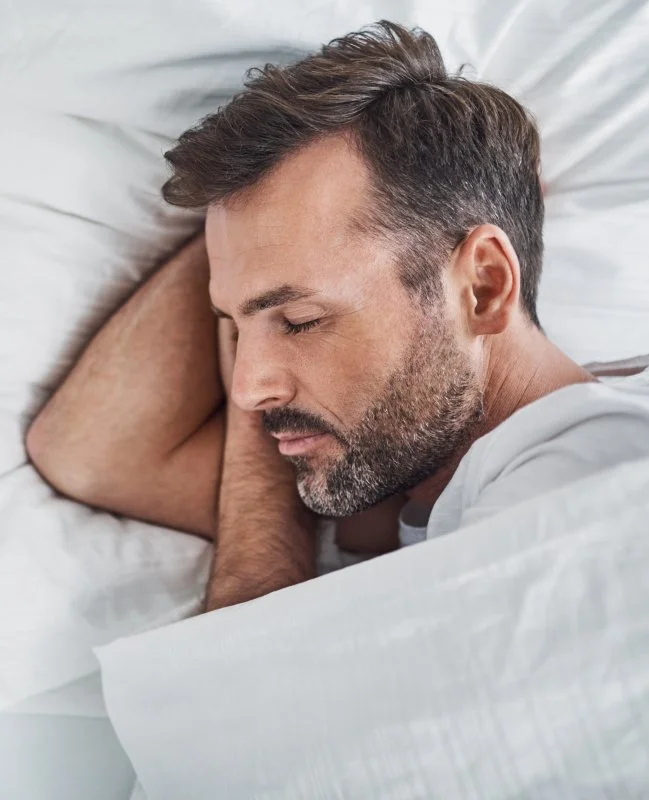 Man sleeping soundly thanks to sleep apnea therapy